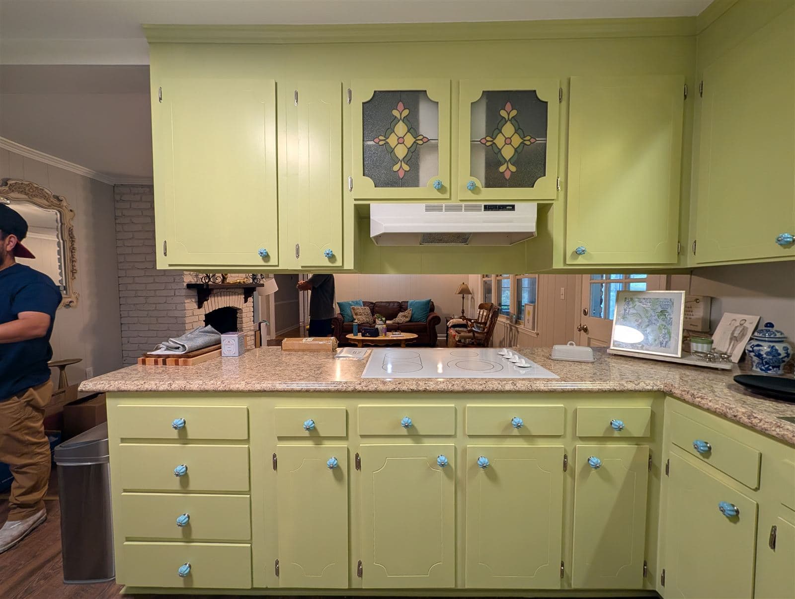 Repainted soft green cabinets with original stained-glass doors and bright new knobs in Taylors, SC