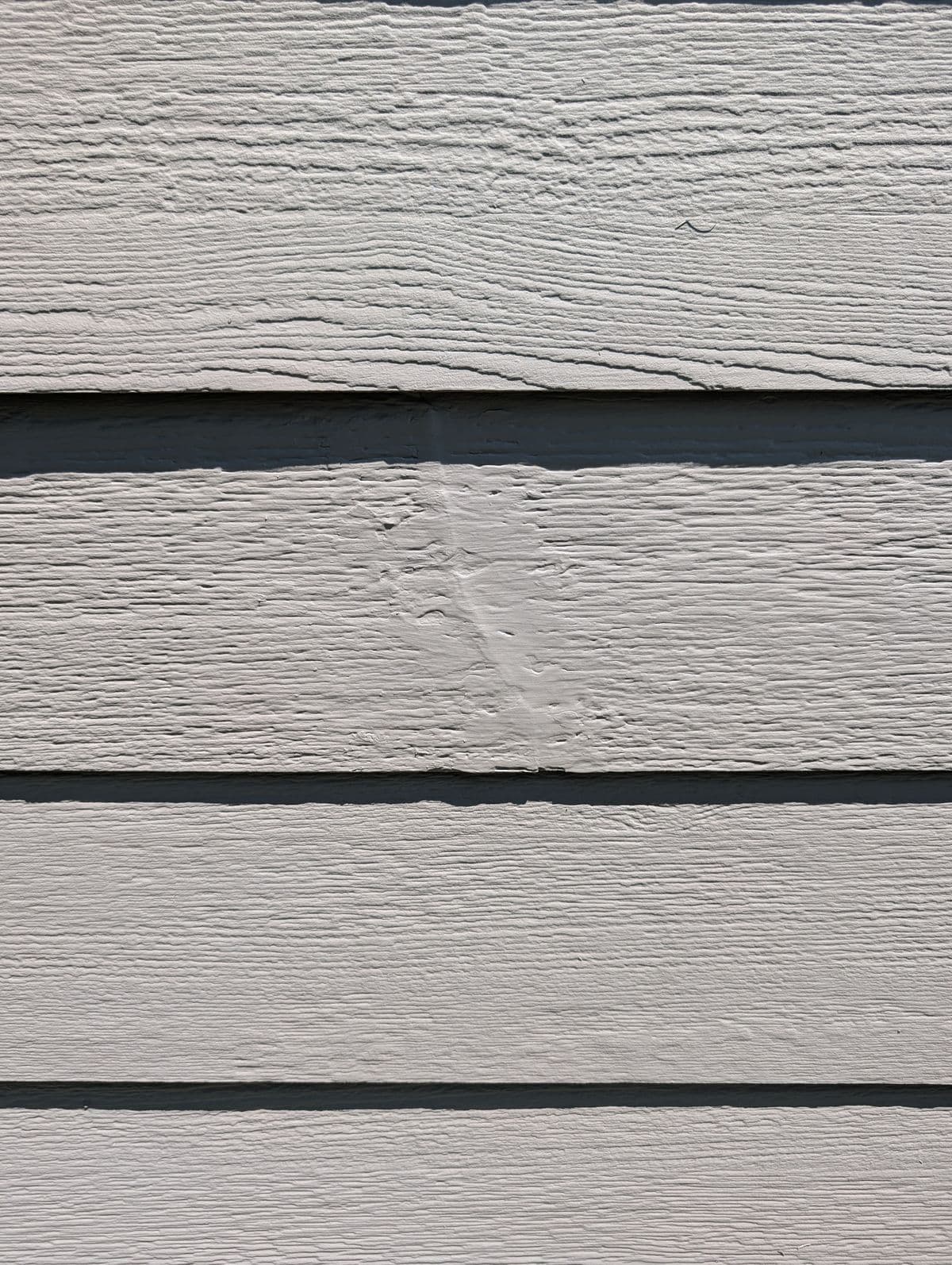 Close-up of a repaired siding crack sealed and painted in Simpsonville, SC