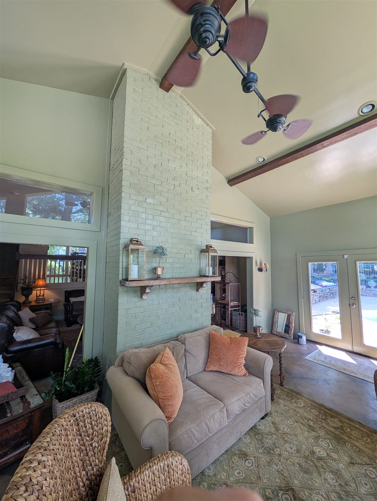 Floor-to-peak brick fireplace, walls, and vaulted ceiling painted one sage green in Pelzer, SC