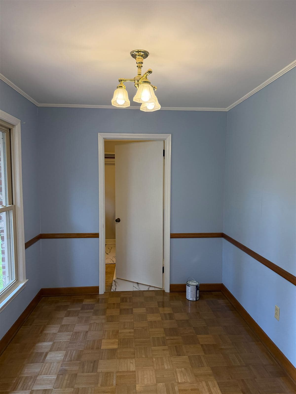 Breakfast room painted a soft blue over primed wallpaper with chair rail and parquet floor in Taylors, SC