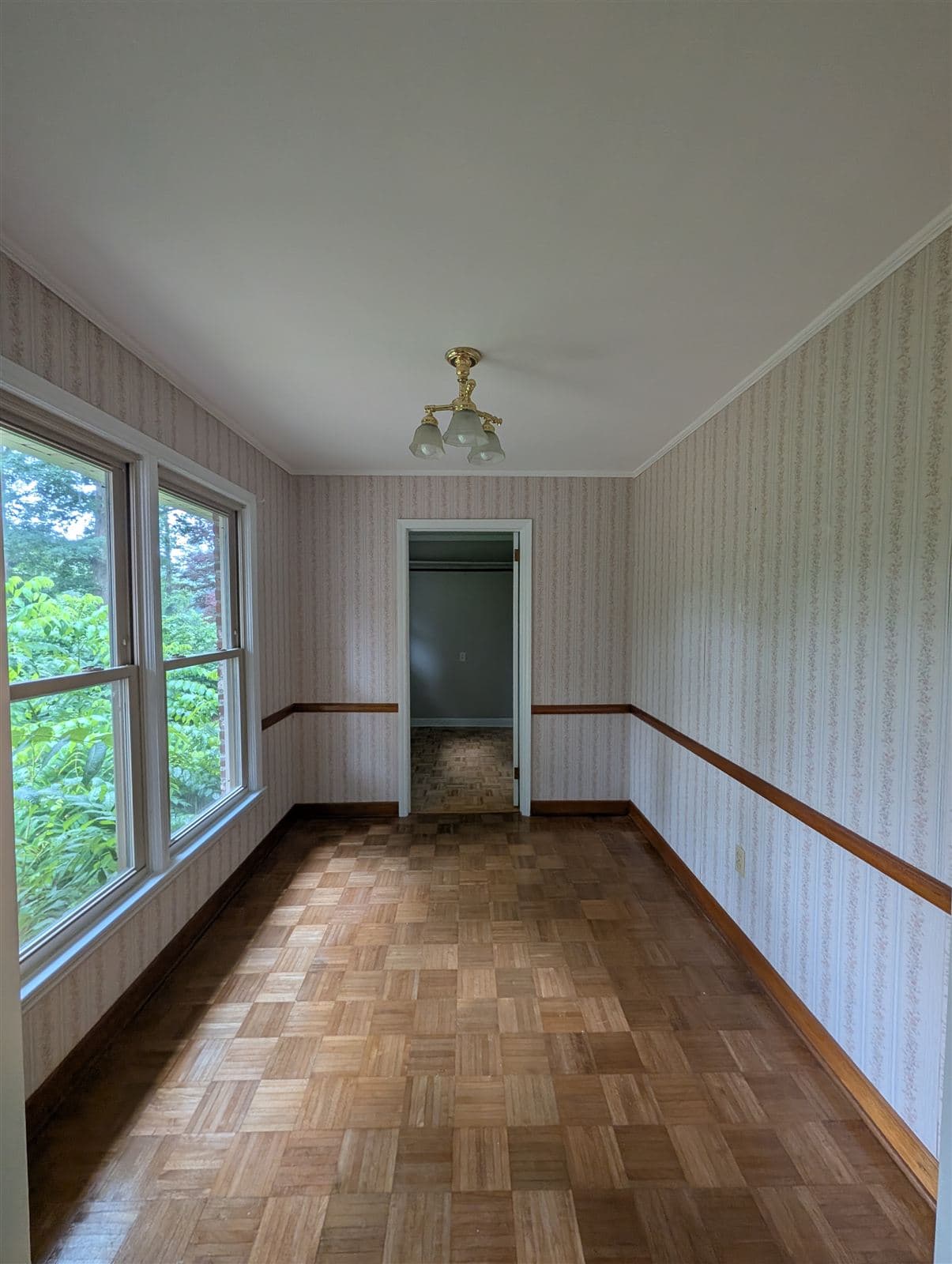 Room covered in old wallpaper over paneling before painting in Taylors, SC
