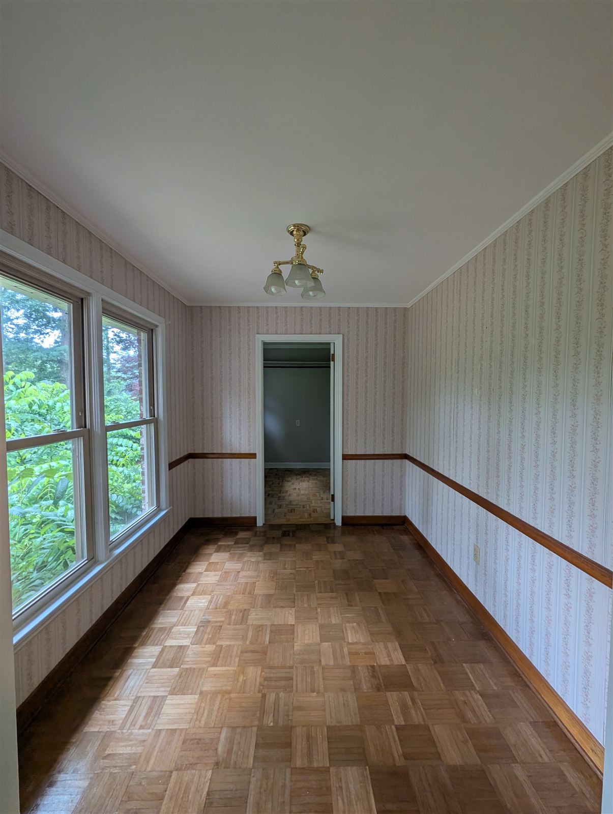 Room covered in old wallpaper over paneling before painting in Taylors, SC